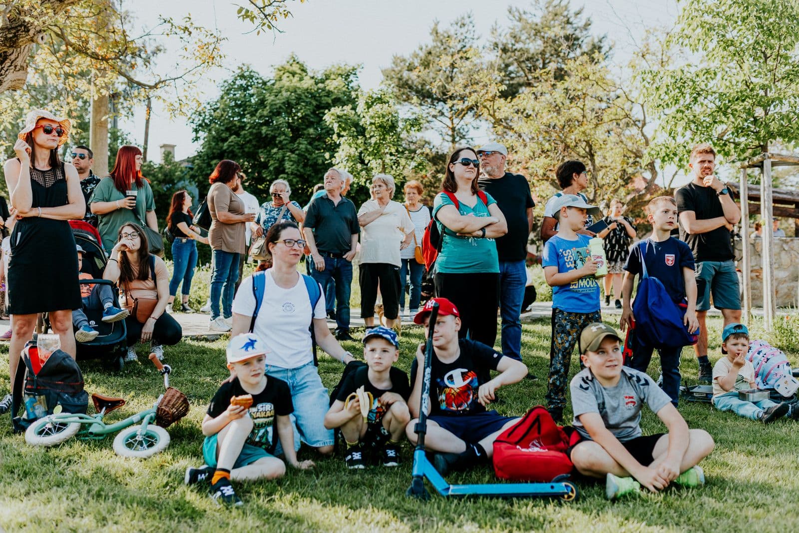 Famílias reunidas na grama de um parque em um dia de sol